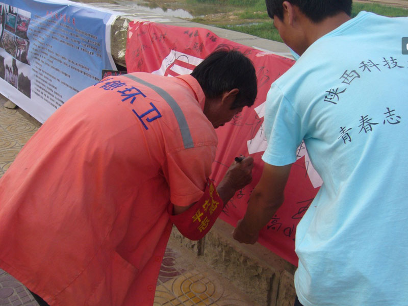 7月21日,陜西科技大學(xué)材料學(xué)院大學(xué)生公益團(tuán)隊(duì)在綏德縣千獅橋廣場(chǎng)舉辦“同飲無定水,保護(hù)母親河”活動(dòng)。圖為一名環(huán)衛(wèi)工人在“保護(hù)母親河”橫幅上簽下名字。