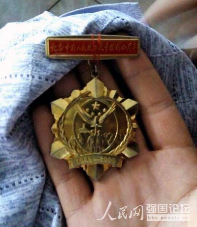 抗戰老兵袁五林向志愿者展示抗戰勝利六十周年時的紀念章。